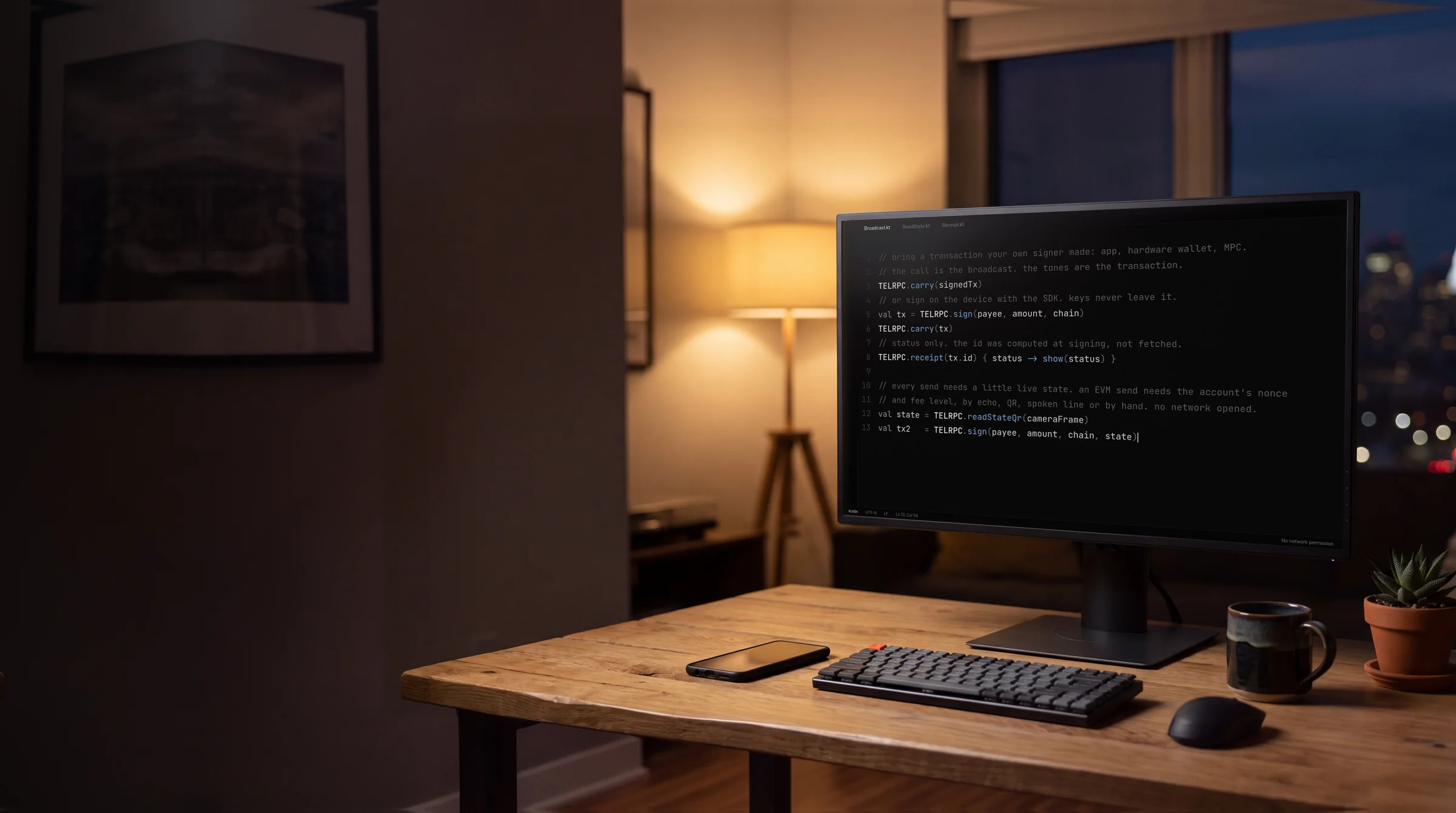 A monitor on a desk at dusk showing code in an editor